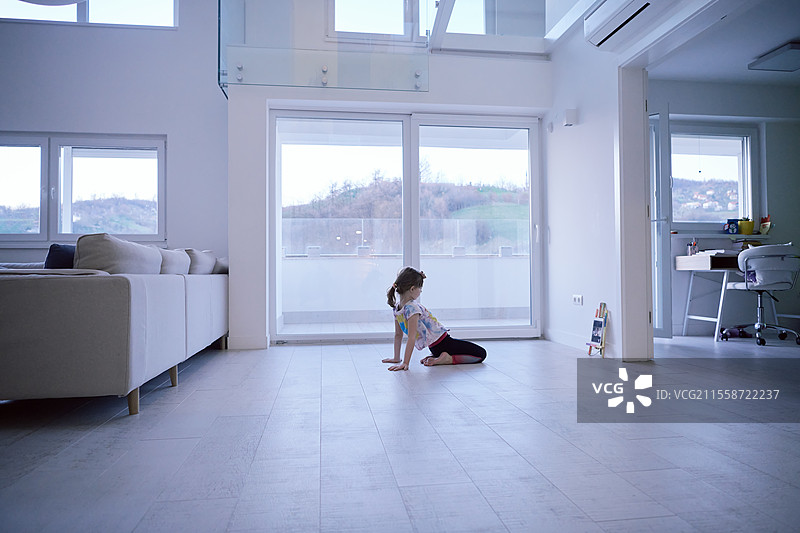 小女孩在家通过平板电脑进行在线培训，正在做现代芭蕾舞练习。现代芭蕾舞学校的在线教育课程。在疫情期间保持社交距离，自我隔离。图片素材