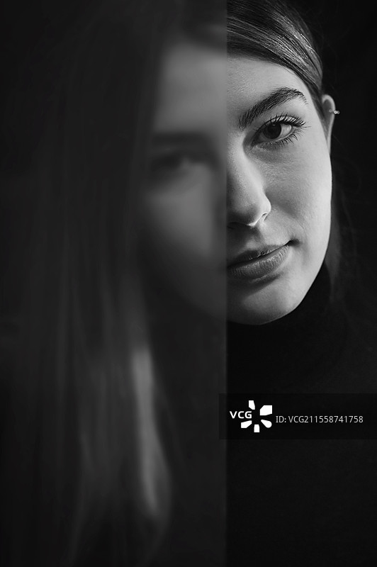 透过半透明玻璃看到的年轻女性特写肖像图片素材