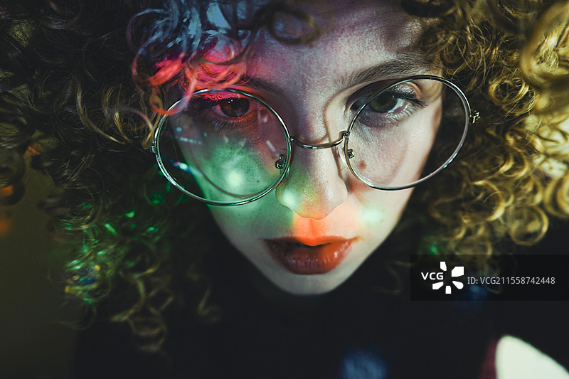 被迷幻灯光照亮的年轻女性肖像图片素材