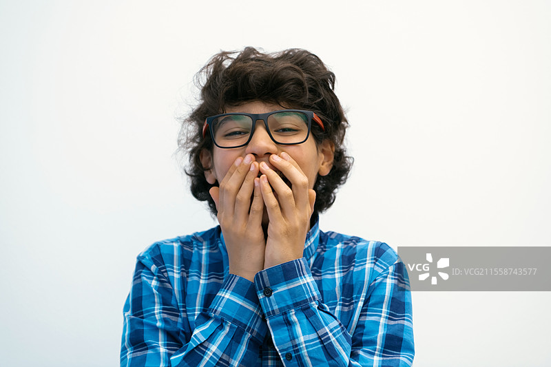 戴着眼镜、穿着休闲校服的阿拉伯少年，头戴帽子，背景为白色空白，展现出聪明的形象。高质量照片。图片素材