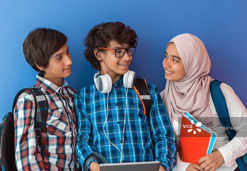 现代阿拉伯青少年因新冠病毒疫情在网上课堂上使用智能手机、平板电脑和笔记本电脑学习。高质量照片。图片素材