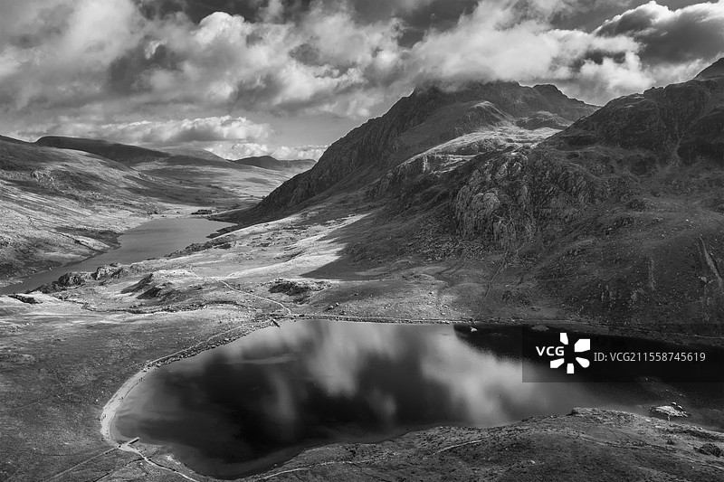 黑白色的无人机航拍图，史诗般的早秋风景，展示了斯诺多尼亚国家公园奥格温山谷的壮丽景色，背景是戏剧性的天空和山脉。图片素材