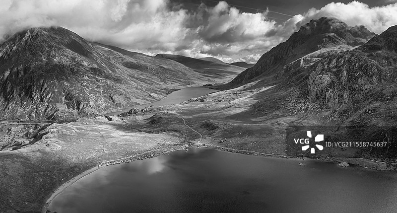 黑白航拍视角的飞行无人机，史诗般的初秋风景图，展示了斯诺多尼亚国家公园奥格温山谷的壮丽景色，背景是戏剧性的天空和山脉。图片素材