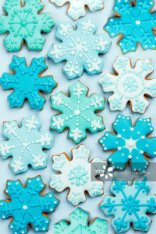 圣诞雪花饼干套装。蓝色背景上的装饰姜饼。甜美可口的节日礼物。圣诞卡片图片素材