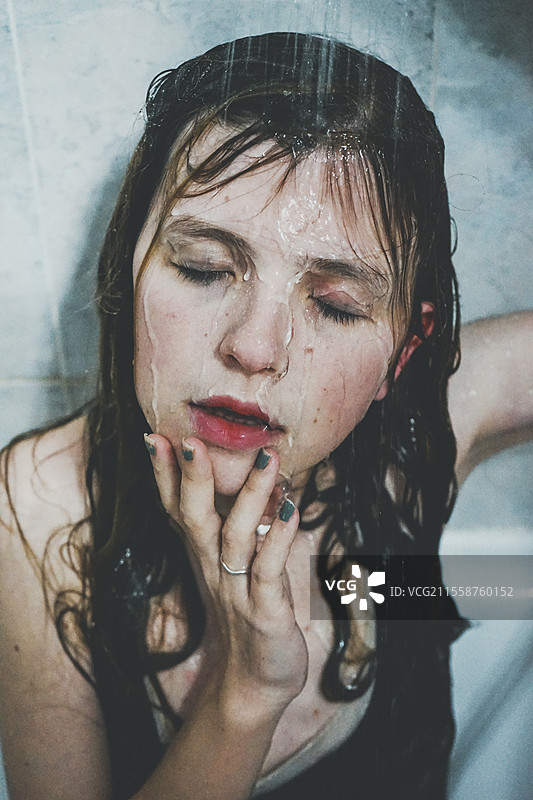 年轻女性在淋浴水下的艺术肖像图片素材