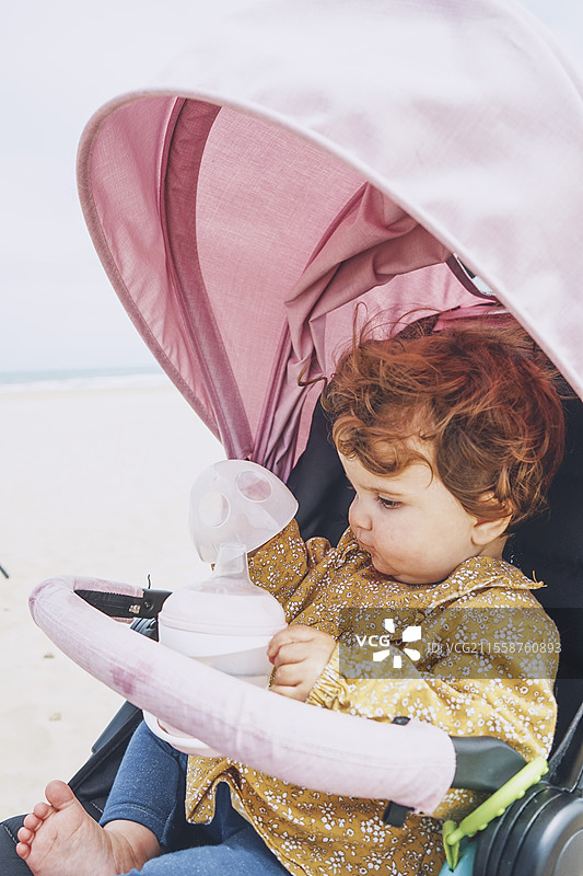 小宝宝正在用瓶子喝水图片素材