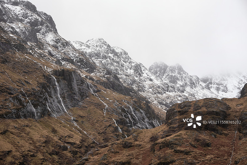 格伦科苏格兰高地的三姐妹山脉雪山壮丽冬季风景，伴随戏剧性的天空图片素材