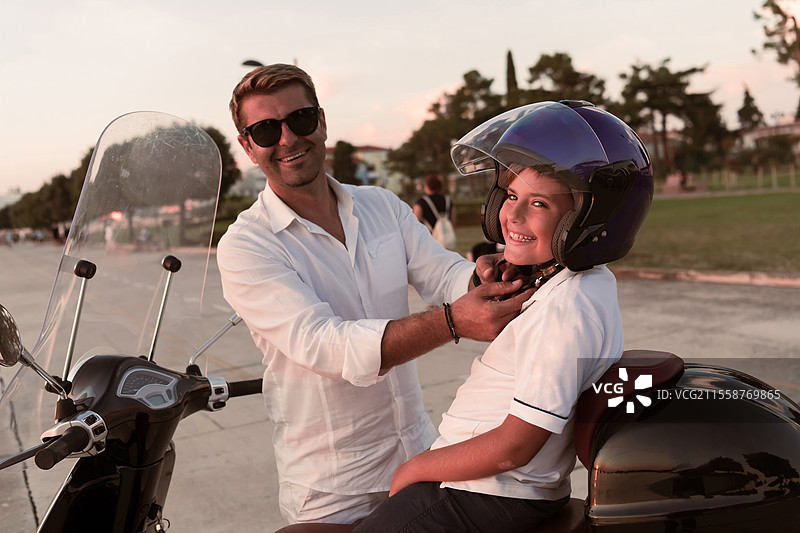 一位父亲和他的儿子在清晨享受海边骑滑板车的假期。选择性对焦。高质量照片。图片素材