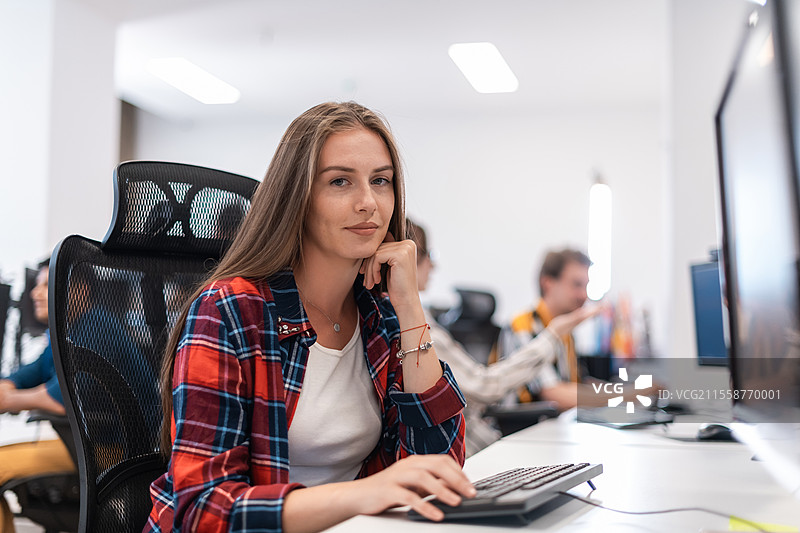 休闲商务女性在现代开放式初创公司办公室内使用桌面电脑。选择性对焦。高质量照片。图片素材