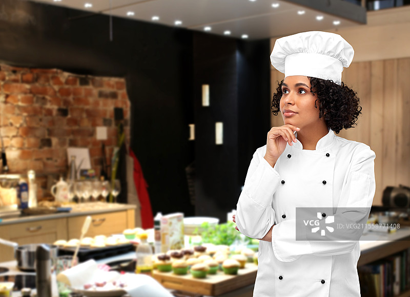 烹饪、烹饪艺术和人物概念 - 思考中的女性厨师，穿着白色厨师帽和外套，背景是餐厅厨房。餐厅里的思考女性厨师。图片素材