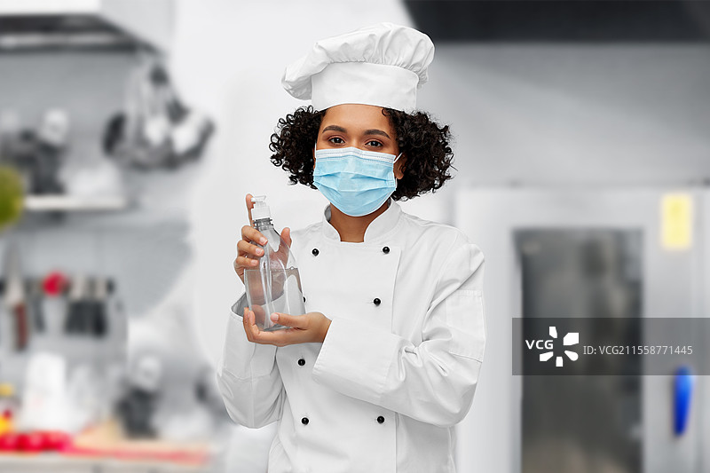 烹饪、安全与健康概念 - 女性厨师佩戴防护口罩和厨师帽，在餐厅厨房背景下使用洗手液或液体肥皂。佩戴口罩的女性厨师与洗手液或肥皂。图片素材