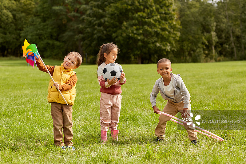 童年、休闲和人们的概念 - 快乐的孩子们在公园里玩风车，享受乐趣。图片素材