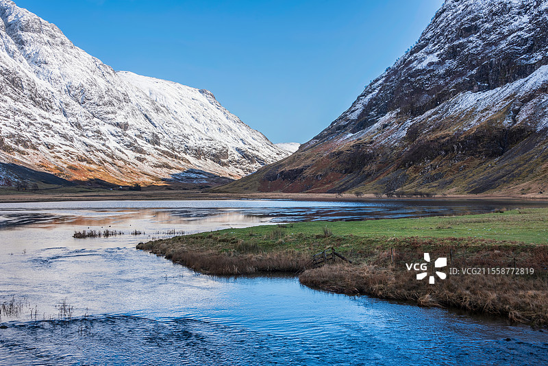 苏格兰高地的阿赫特里奥汉湖美丽的冬季风景，宁静的水面上映出惊人的倒影，湛蓝的天空清澈如水。图片素材