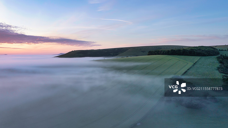 美丽的无人机拍摄的风景图，春天日出时雾海在南唐斯英格兰乡村翻滚。图片素材