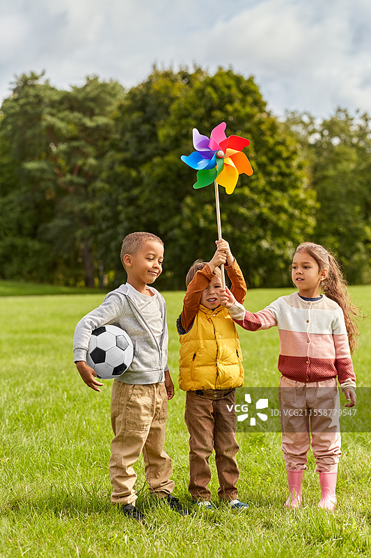 童年、休闲和人们的概念 - 快乐的孩子们在公园里玩风车，享受乐趣。图片素材
