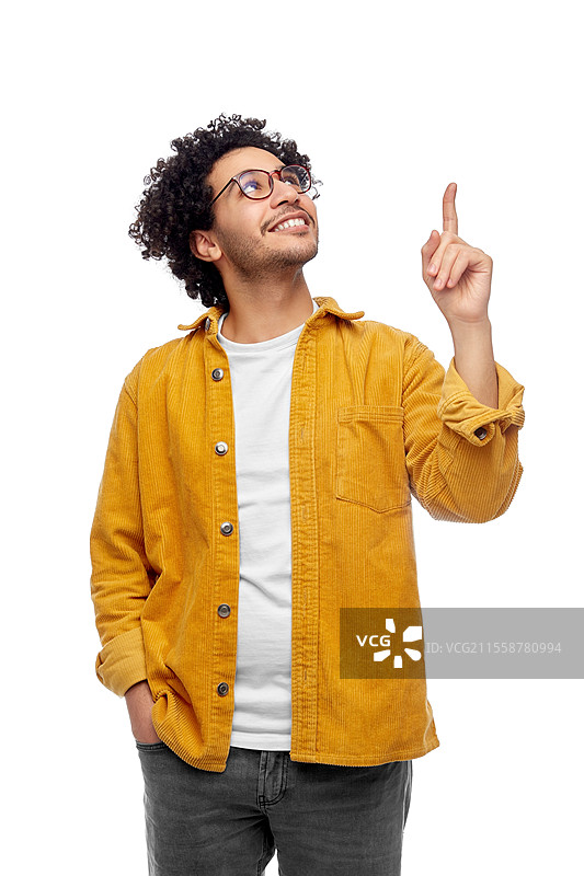 人们与时尚的概念 - 一位快乐微笑的戴眼镜男士穿着黄色夹克，指着上方，背景为白色。快乐微笑的戴眼镜男士指着上方。图片素材