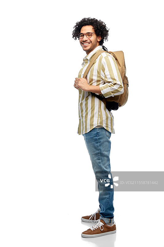 旅行、时尚和教育概念 - 戴眼镜的快乐微笑男士背着背包，背景为白色。戴眼镜的快乐微笑男士背着背包。图片素材