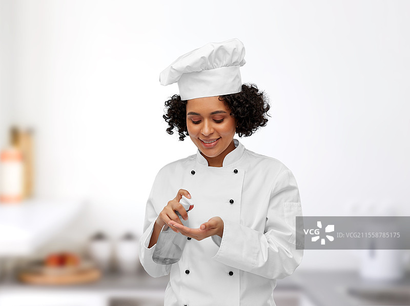 烹饪、烹饪艺术和人们的概念 - 开心微笑的女厨师在餐厅厨房背景下使用洗手液或液体肥皂。女厨师正在使用洗手液或液体肥皂。图片素材