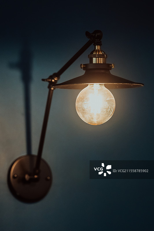 现代蓝色墙壁上的旧灯泡。选择性对焦。高质量照片。图片素材