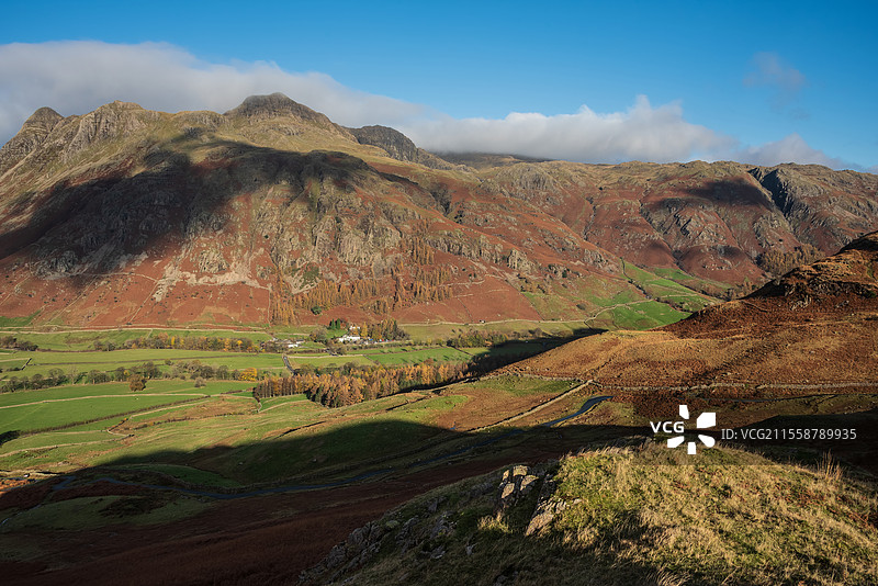 令人惊叹的秋季风景图，俯瞰皮克·奥布利斯科（Pike O'Blisco）朝向朗代尔派克斯（Langdale Pikes）和山脉，阳光照耀在山脉和山谷上。图片素材