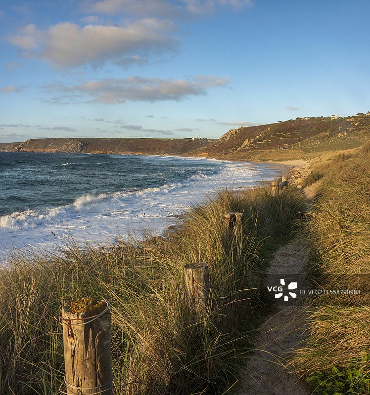 康沃尔州塞农湾的美丽风景，日落时分从草地沙丘上俯瞰，天空阴郁，海面长时间曝光的动态效果。图片素材