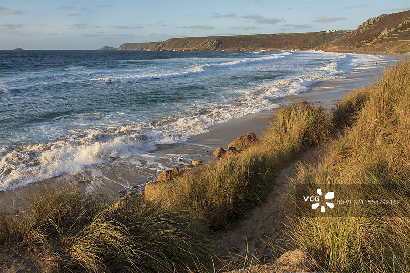 康沃尔州塞农湾的美丽风景，日落时分从草地沙丘上俯瞰，天空阴郁，海面长时间曝光的运动效果。图片素材
