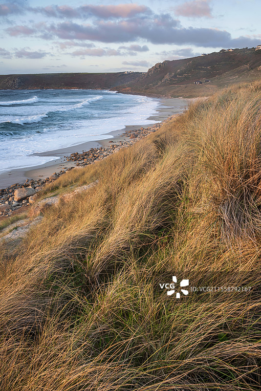 康沃尔州塞农湾的美丽风景，日落时分从草地沙丘上俯瞰，天空阴郁，海面长时间曝光的动感。图片素材