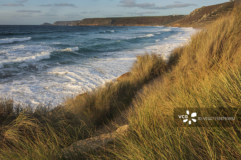 康沃尔州塞农湾的美丽风景，日落时分从草地沙丘上俯瞰，天空阴郁，海面长时间曝光的动感。图片素材