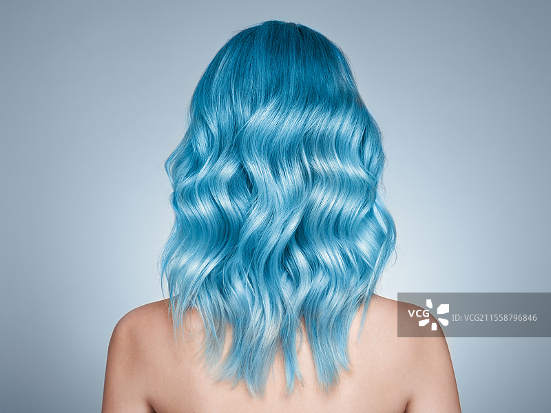 蓝色染发的时尚模特女孩。卷发女孩。拥有完美健康染发的模特。图片素材