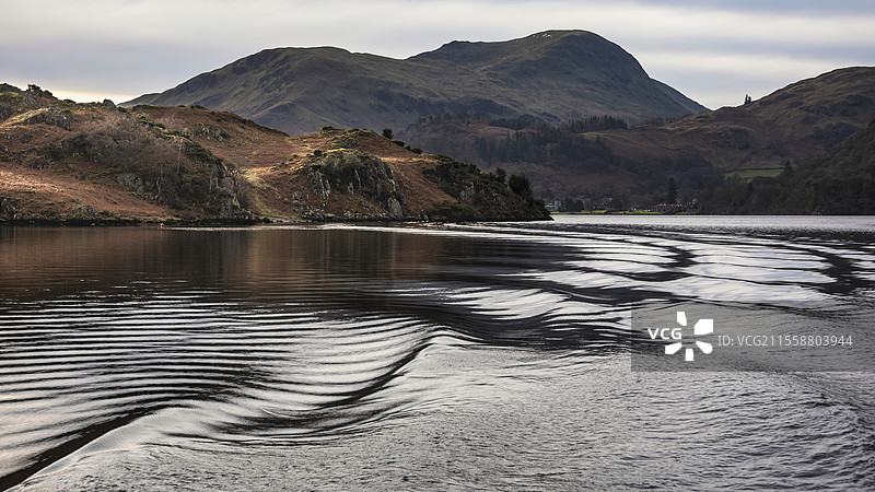 美丽的冬季风景，从湖区的乌尔斯沃特湖上的船上观看，水面出现不寻常的涟漪波纹。图片素材