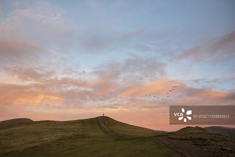 美丽的冬季日落景观，位于湖区的拉特里格山顶上，一位独自欣赏日落的人。图片素材