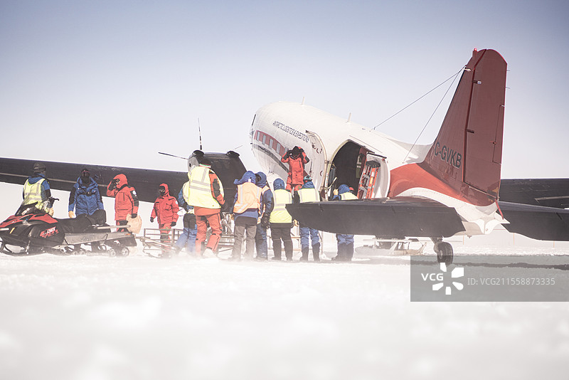 技术人员在康科迪亚的供应飞机上装卸货物。法语（蓝色）和意大利语（红色）技术人员协助卸载巴斯勒 - 道格拉斯DC3飞机，该飞机每月在夏季多次向康科迪亚站运送科学和/或技术设备。一个由6到20人组成的团队仅需3分钟即可卸下2吨货物，将同样数量的设备重新装上飞机，并为飞机加注煤油。完成这些操作后，飞机便准备再次起飞。康科迪亚南极研究站，Dome C高原，东南极。图片素材