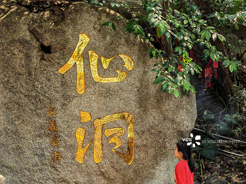 仙洞深圳凤凰山，凤岩古庙。孩童走过仙洞石刻崖壁图片素材