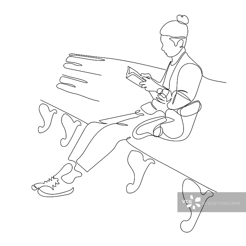 年轻男子坐在长椅上阅读一本书图片素材