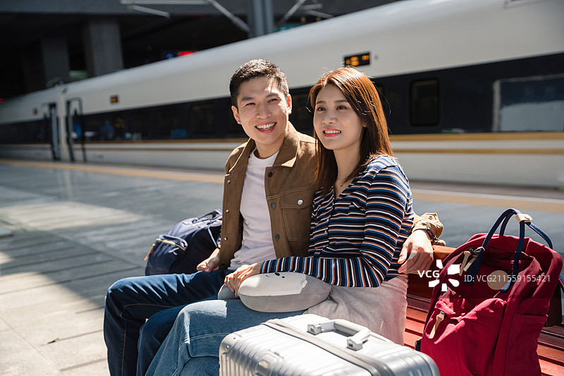 高铁站站台内坐在座位上候车的青年情侣图片素材