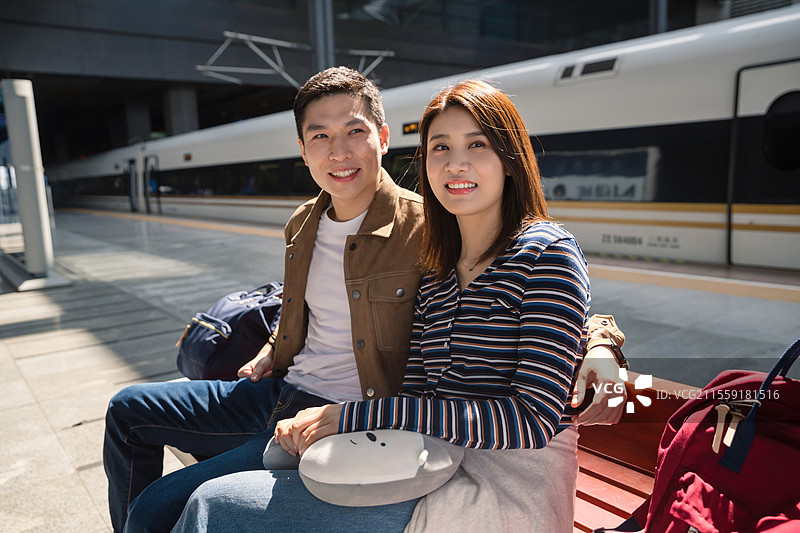 高铁站站台内坐在座位上候车的青年情侣图片素材