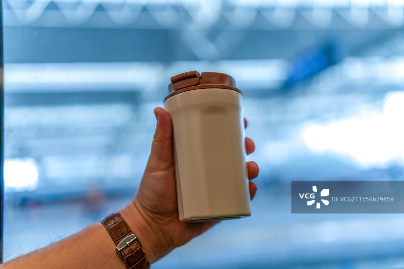 在城市环境中时尚地手持现代旅行咖啡杯图片素材