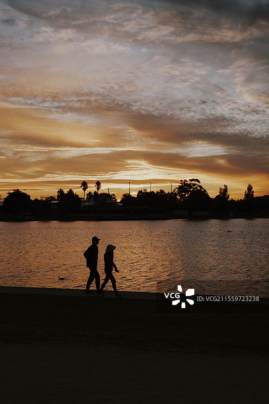 阿尔伯特公园，日落时刻湖边散步的人图片素材