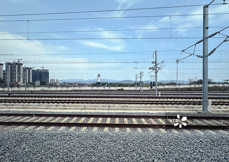高铁动车火车站窗外自然风景远处建筑近处铁轨运输轨道图片素材