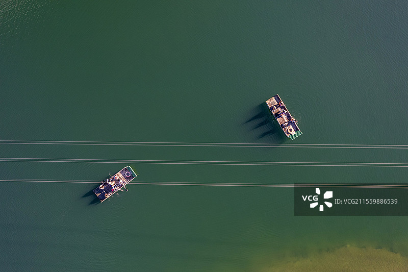 碧绿湖水上的一些游客乘船在游览的俯瞰图图片素材