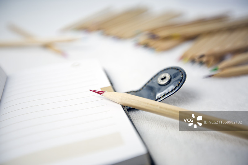 白色桌面上的彩色铅笔和笔记本图片素材