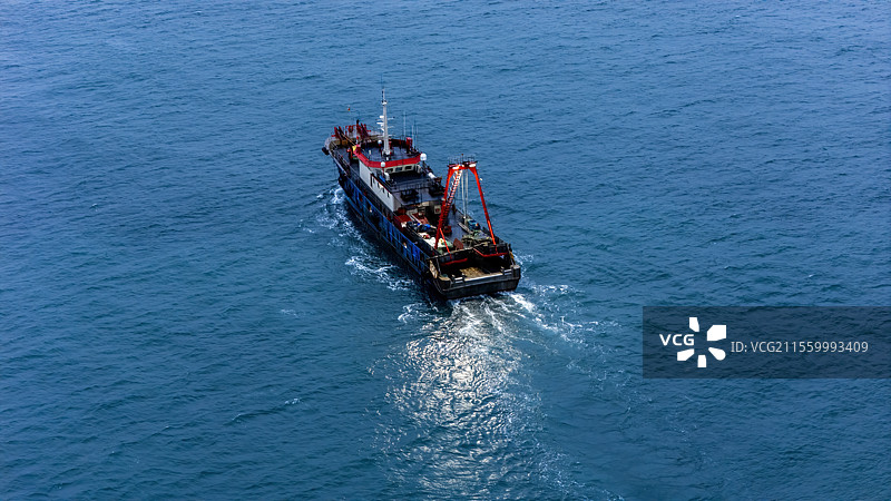 航拍蓝调时刻下出海的一艘渔船图片素材