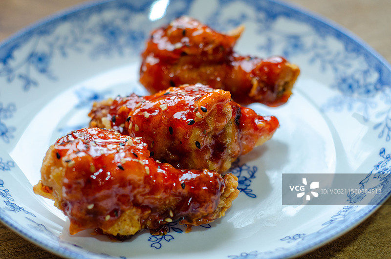 蓝白花纹盘装撒有芝麻的美味鸡翅图片素材