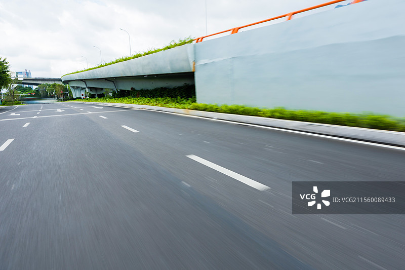 现代城市中在晴朗天空下的路面，突出现代建筑与城市线条的简洁感，是汽车广告背景图的理想选择，展现出开阔图片素材