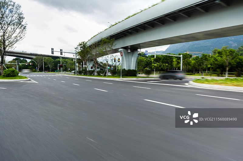 现代城市中在晴朗天空下的路面，突出现代建筑与城市线条的简洁感，是汽车广告背景图的理想选择，展现出开阔图片素材