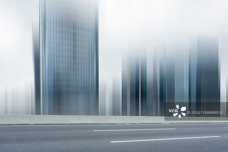 现代城市中在晴朗天空下的路面，突出现代建筑与城市线条的简洁感，是汽车广告背景图的理想选择，展现出开阔图片素材