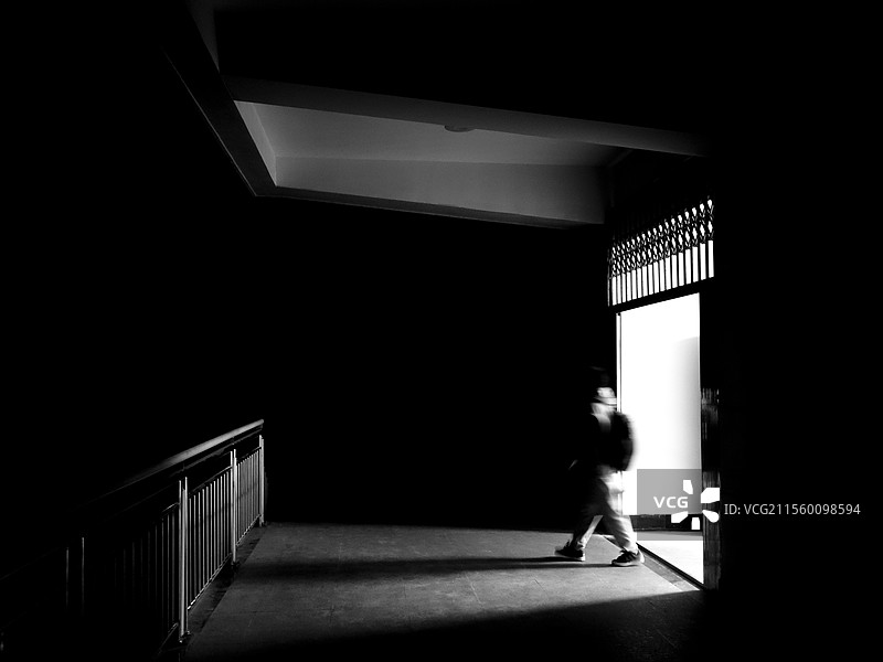 一个人从门里走出的慢门黑白照片图片素材