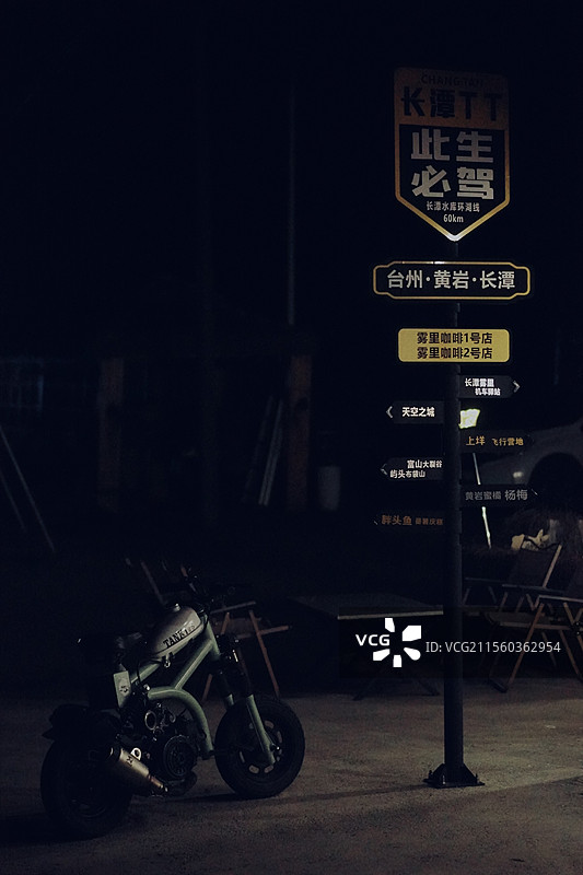 夜间路标下的摩托车图片素材