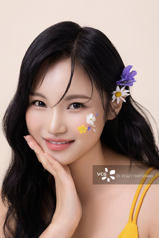 一位美丽女性的肖像，脸上涂有面部彩绘和花朵。图片素材