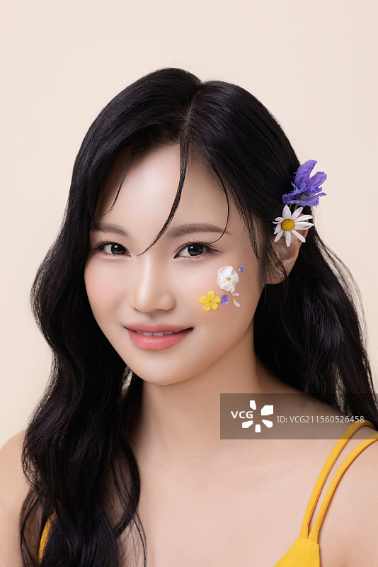 一位美丽女性的肖像，脸上涂有面部彩绘和花朵。图片素材